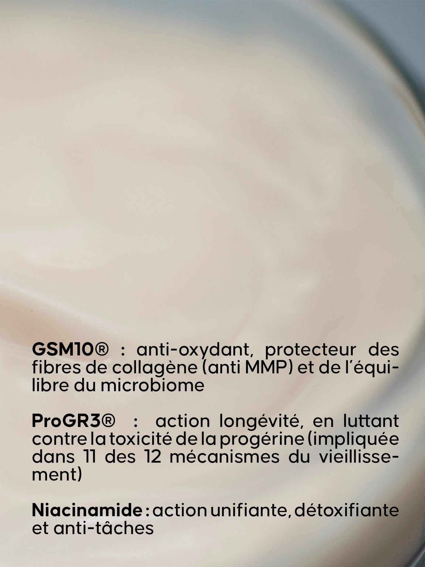 Texture onctueuse de La Crème Fluide en très gros plan, avec un texte en bas de l’image présentant ses ingrédients clés (GSM10®, ProGR3® et niacinamide)