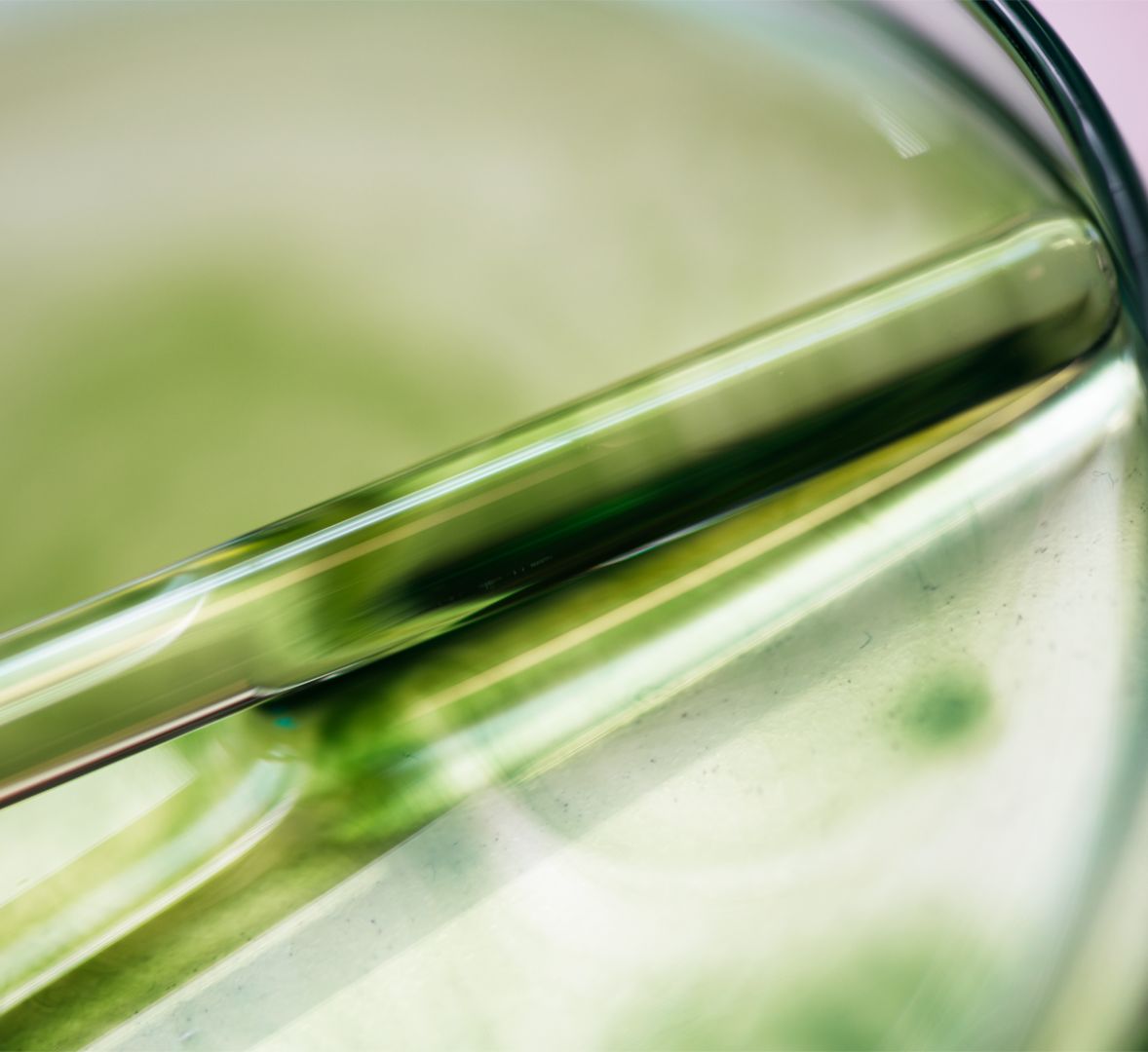 Tube en verre avec un liquide vert, photographié en gros plan sur un fond flou