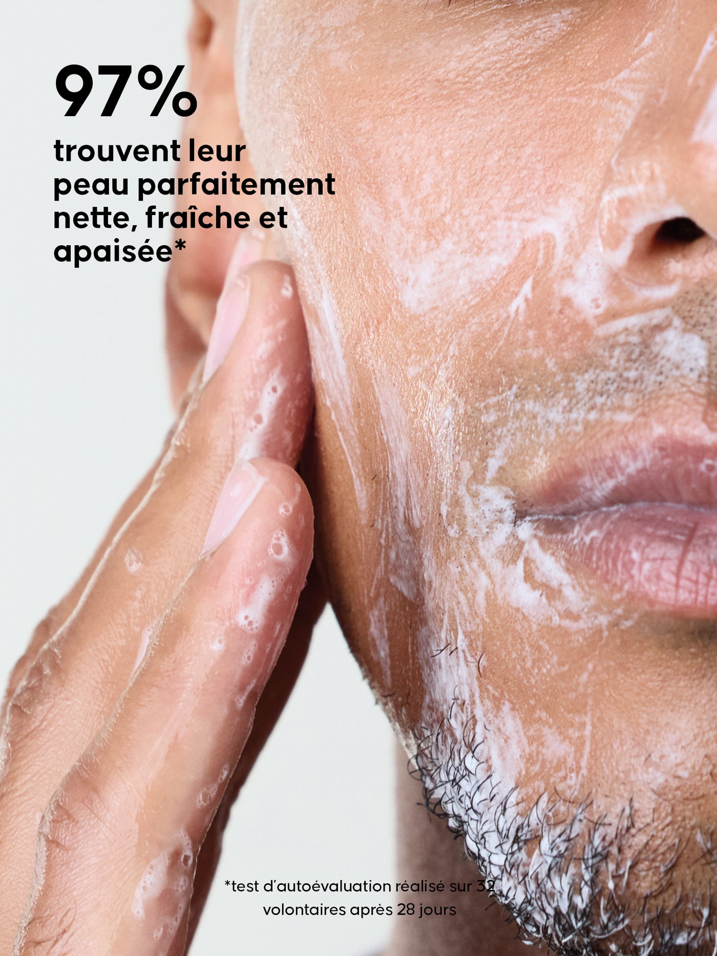 Gros plan d’une personne appliquant L'Émulsion Nettoyante sur son visage, avec un texte indiquant “97% trouvent leur peau parfaitement nette, fraîche et apaisée”