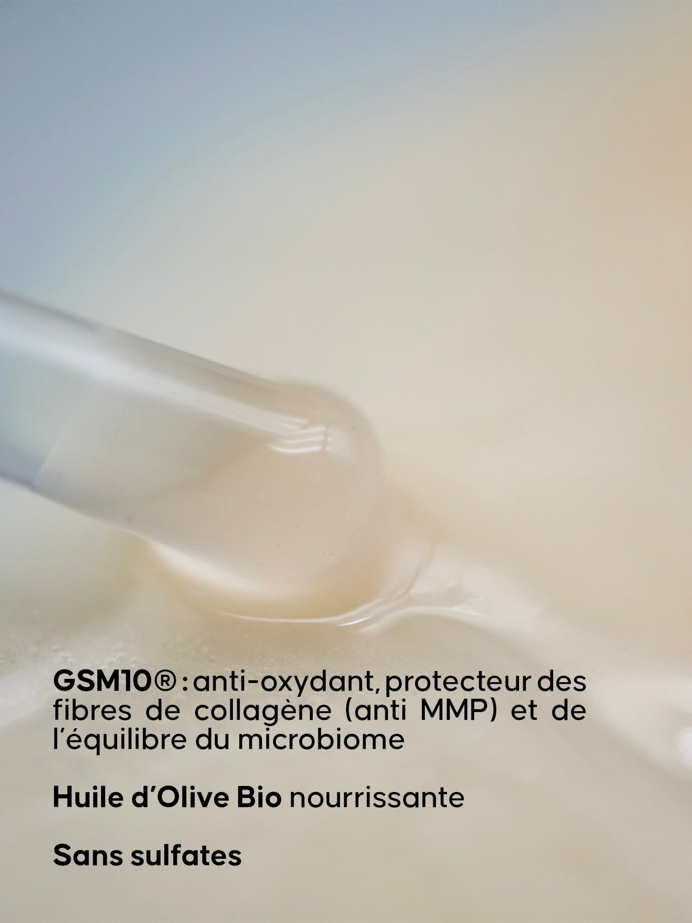 Pipette contenant un liquide clair en gros plan, avec en dessous un texte mentionnant GSM10®, l’huile d’olive bio nourrissante et l’absence de sulfates